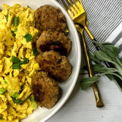 sage and maple filled turkey sausage patties served on a plate with scrambled eggs